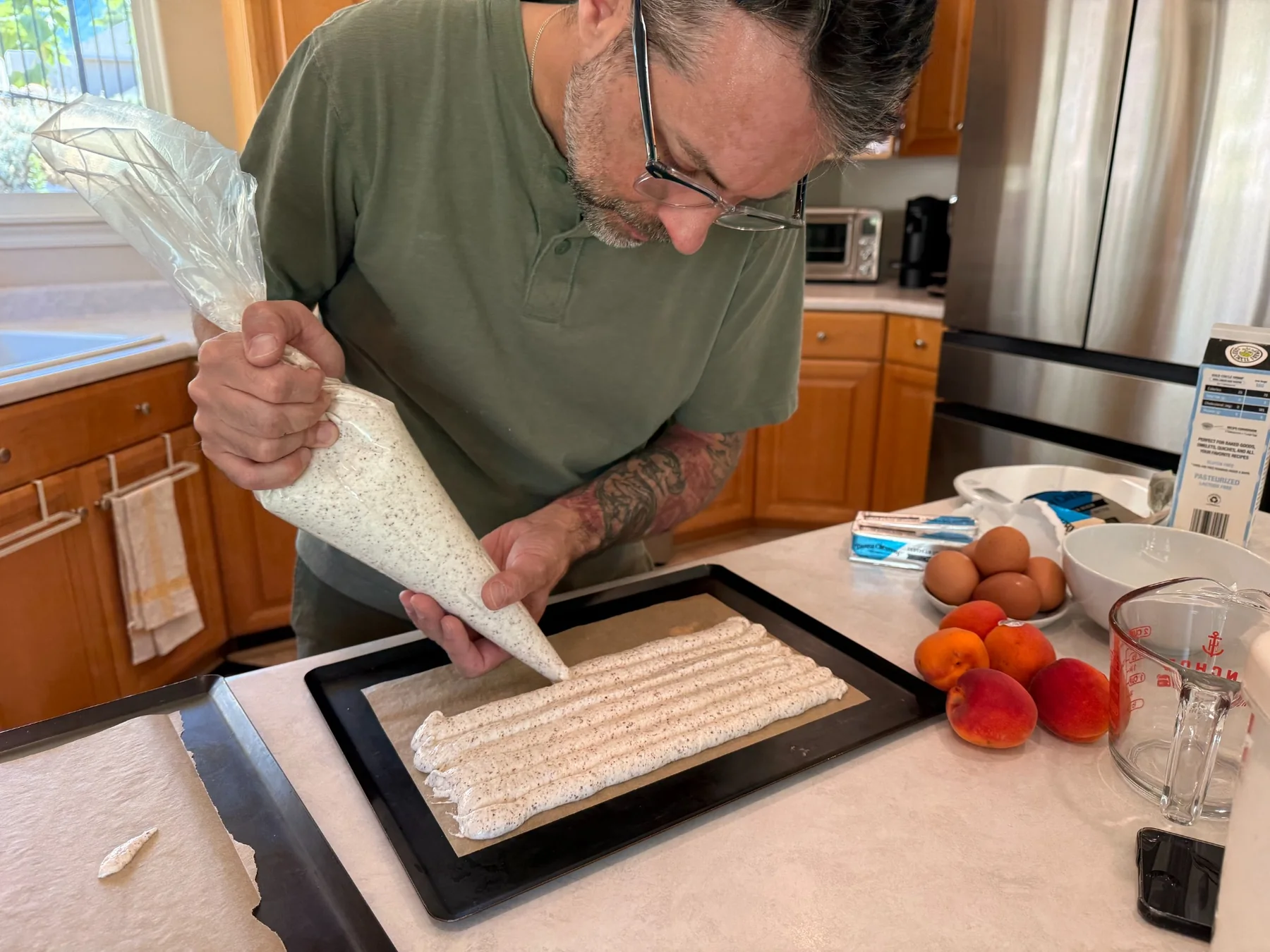 Jérôme piping pastry onto a baking tray in the kitchen