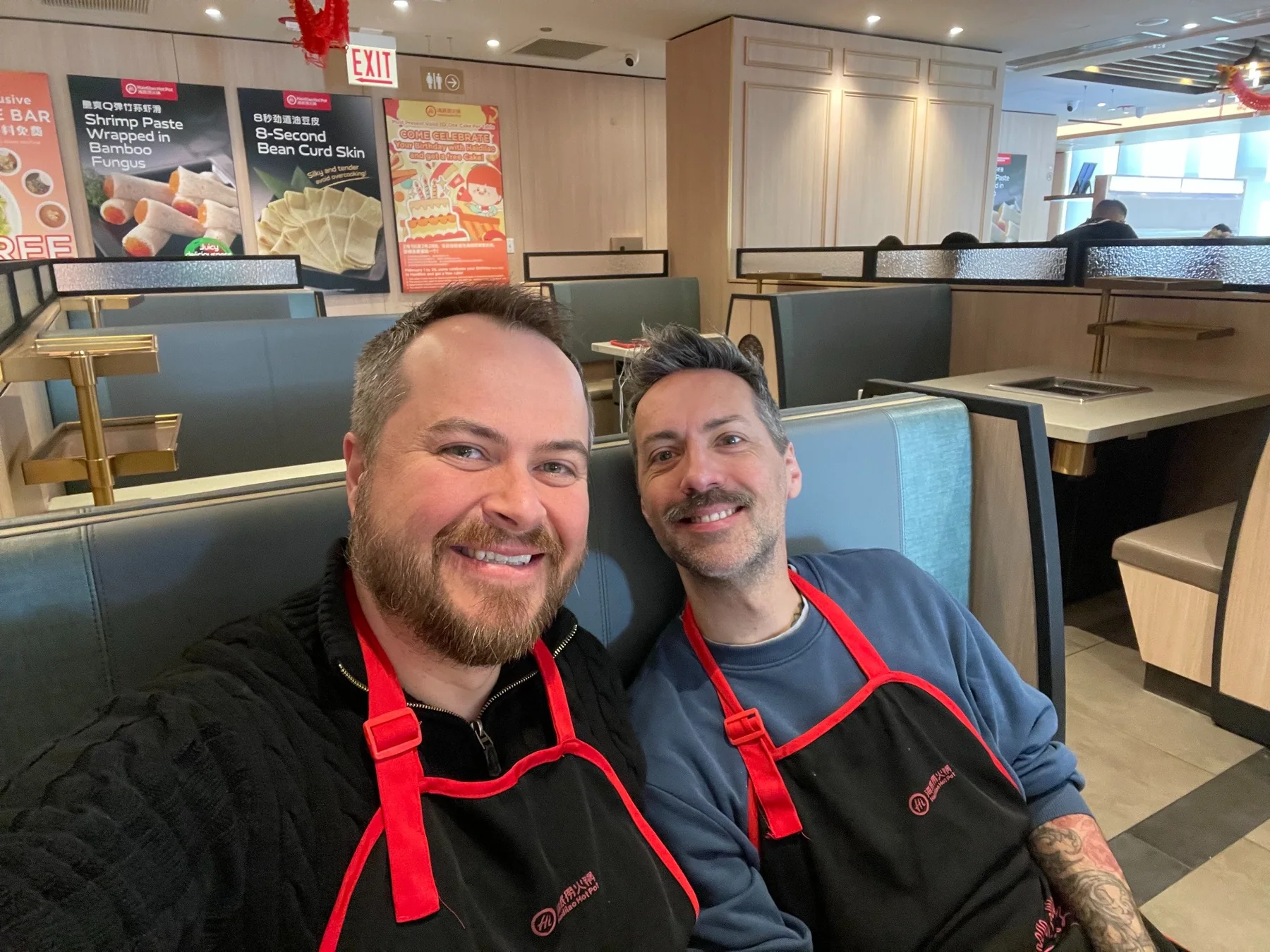 Devon and Jérôme wearing aprons during a restaurant cooking experience